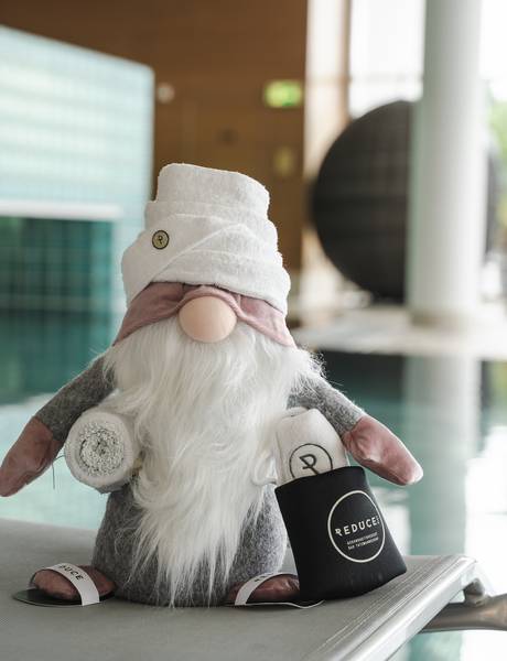 REDUCE gnome on a lounger in front of the indoor pool at Hotel Vital