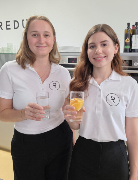 Dieticians Johanna Obermann and Carolina Richter with a glass in their hand as a sign that you should make sure you drink enough fluids.