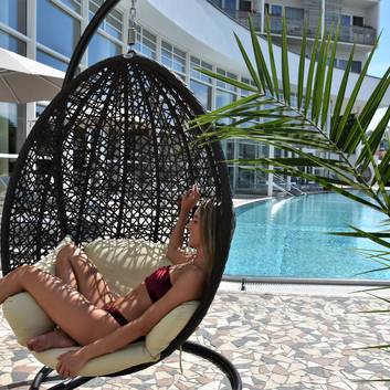 Lady in a hanging chair by the outdoor pool at Reduce Hotel Vital (c) Pavel Laurencik.