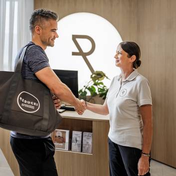 Therapeutin begrüßt Gast im BodyLAB